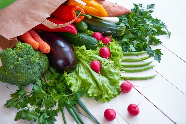 Świeże warzywa organiczne na tle białych desek, widok z góry. Koncepcja zdrowej żywności.