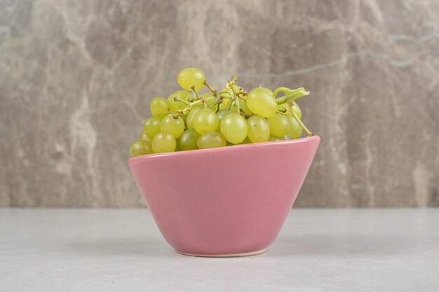 Świeże zielone winogrona w różowej misce