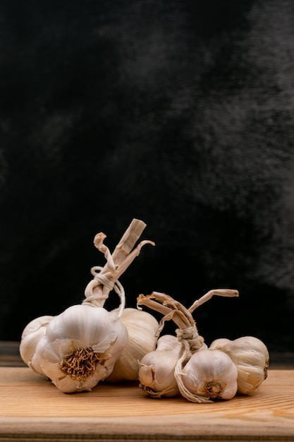 Świezi biali garlics na drewnianej desce