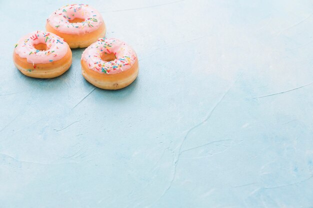 Świezi różowi donuts na błękitnym tle