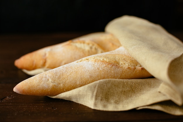 Bezpłatne zdjęcie Świeżo upieczone bagietki. dwa świeżo piec baguette zawijającego w piekarni.