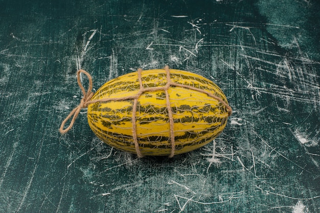 Bezpłatne zdjęcie Świeży melon z nitką na marmurowej powierzchni