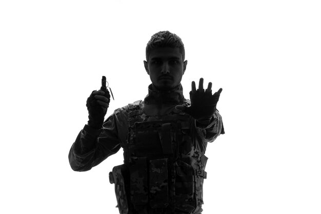 Sylwetka żołnierza armia twardy przystojny poważny silny żołnierz w mundurze zatrzymujący się z granatem
