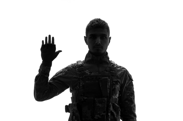 Sylwetka żołnierza poważny przystojny silny twardy żołnierz armii w mundurze wita się