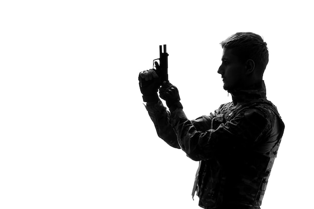 Bezpłatne zdjęcie sylwetka żołnierza twardy przystojny poważny silny żołnierz armii w mundurze rozpoczynający pożar