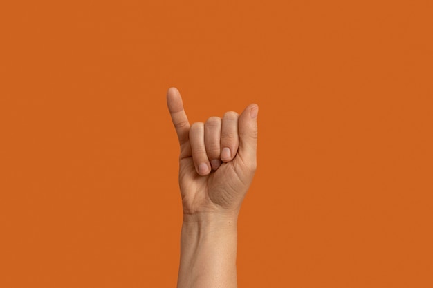 Symbol języka migowego na pomarańczowym tle