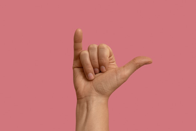 Symbol języka migowego na różowym tle