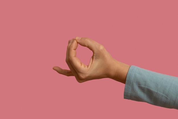 Symbol języka migowego na różowym tle