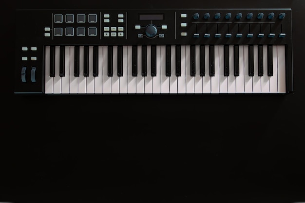 Syntezator klawiszy fortepianu na czarnym tle flat lay