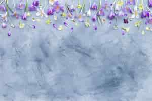 Bezpłatne zdjęcie szare i białe tło z teksturą z obramowaniem fioletowe i białe wiosenne kwiaty