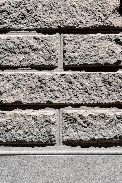 Szary mur z cegły cementowej na zewnątrz tło
