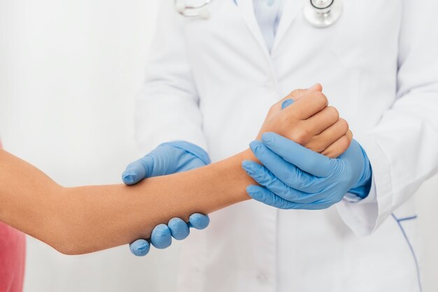 Szczegół lekarz sprawdzający rękę dziewczyny