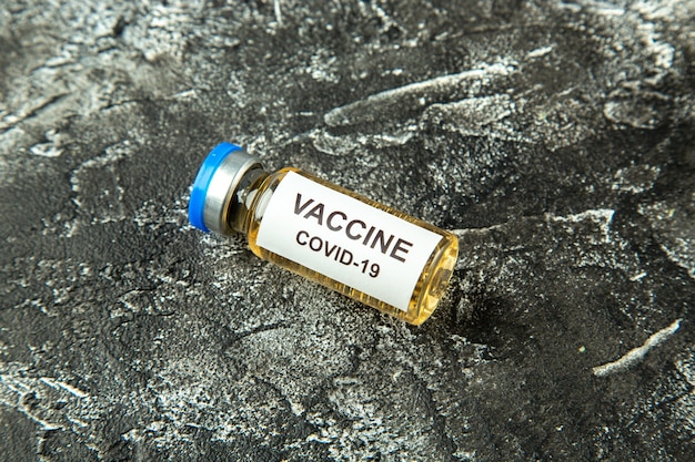 Szczepionka antywirusowa z widokiem z przodu w małej kolbie na szarym tle laboratorium nauki o zdrowiu pandemiczny wirus covid-szpital izolacji