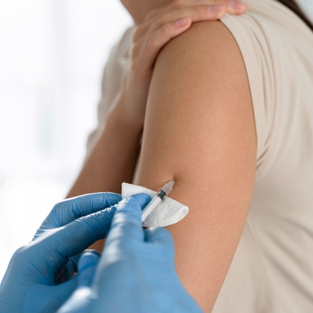 Szczepionka na koronawirusa w ramię kobiety