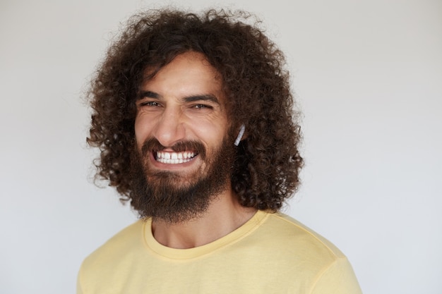 Szczęśliwa atrakcyjna młoda brunetka kręcone mężczyzna pokazuje swoje przyjemne emocje, demonstrując swoje białe idealne zęby, uśmiechając się szeroko