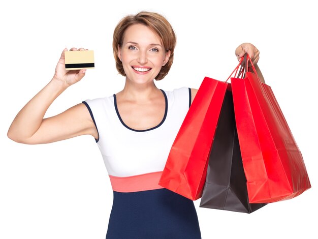 Szczęśliwa biała kobieta z zakupem i kartą kredytową na białej ścianie