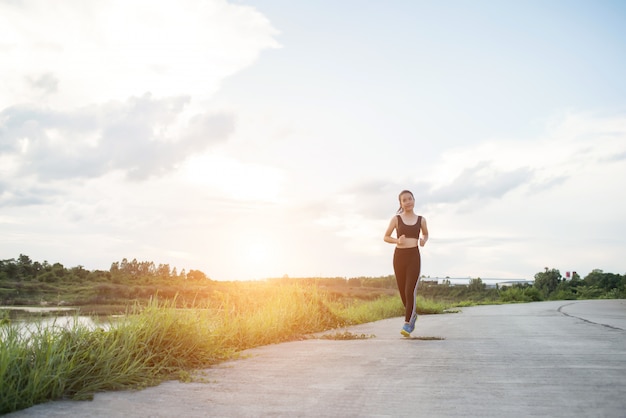 Szczęśliwa biegacz kobieta biega w parkowym jogging ćwiczeniu.