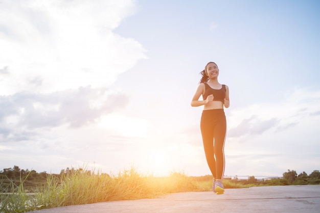 Szczęśliwa biegacz kobieta biega w parkowym jogging ćwiczeniu.