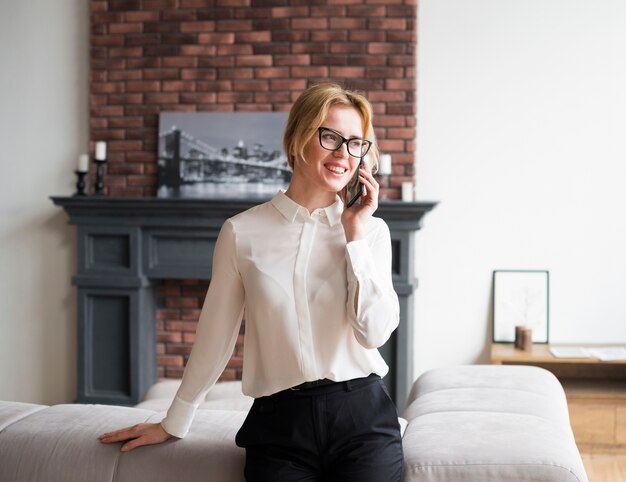 Szczęśliwa biznesowa kobieta opowiada na telefonie