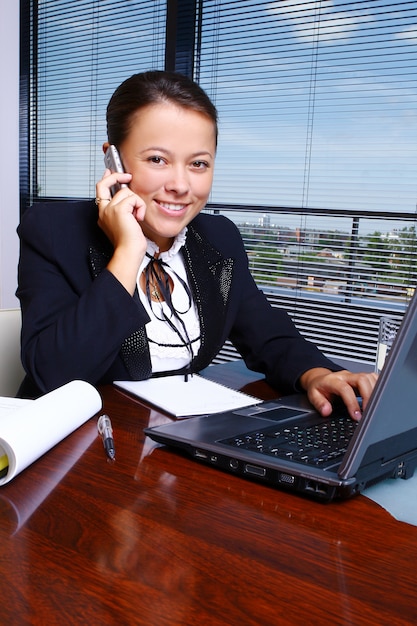 Bezpłatne zdjęcie szczęśliwa biznesowa kobieta w biurze