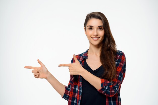 Szczęśliwa caucasian kobieta wskazuje palec opuszczać