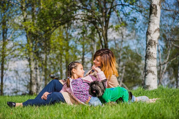 Szczęśliwa dziewczyna siedzi z matką w parku