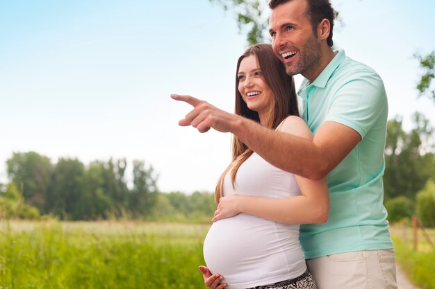 Szczęśliwa i podekscytowana para w ciąży, patrząc od hotelu