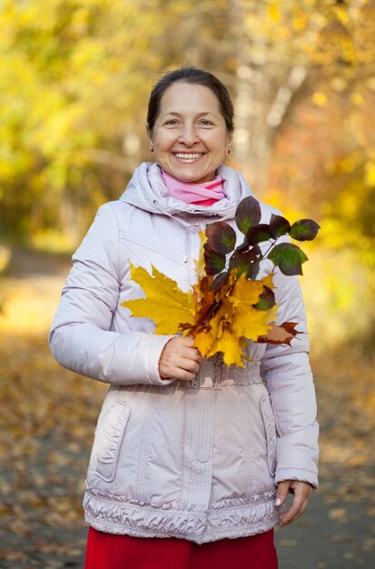 Szczęśliwa kobieta dojrzałych w parku jesienią