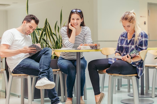 Bezpłatne zdjęcie szczęśliwa kobieta między studiowaniem przyjaciół