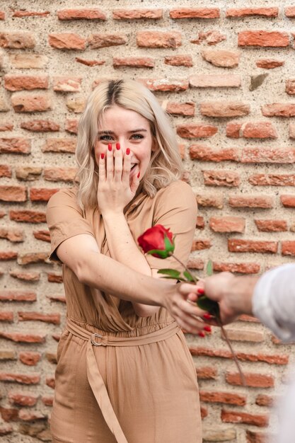Szczęśliwa kobieta odbiera róży od mężczyzna