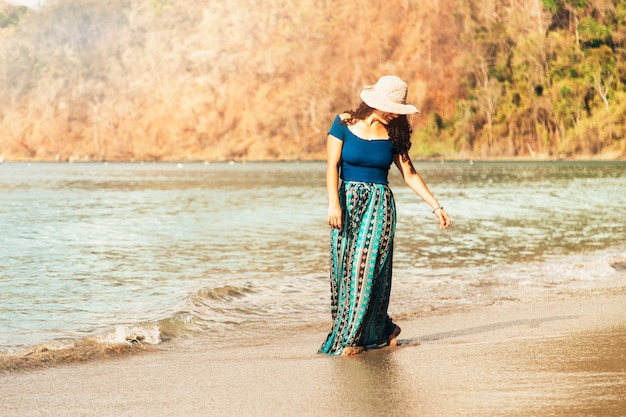 Bezpłatne zdjęcie szczęśliwa kobieta spaceruje wzdłuż morza