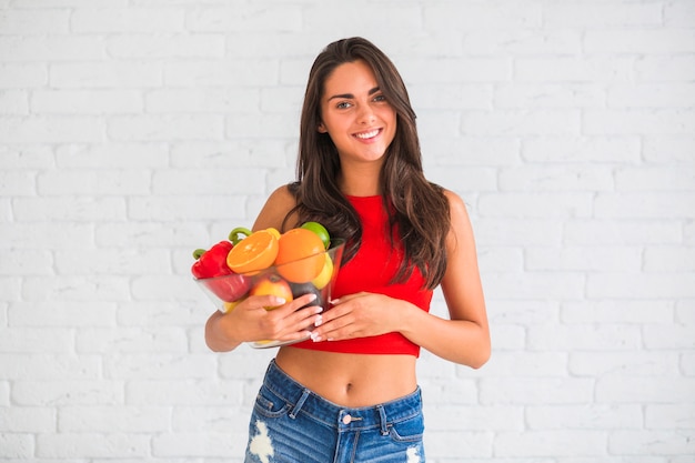 Szczęśliwa kobieta trzyma kolorowych świeżych owoc i warzywo