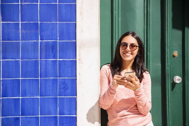 Szczęśliwa kobieta używa smartphone outdoors