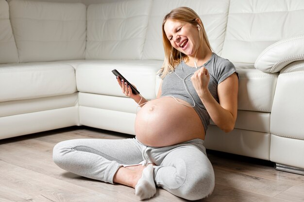 Szczęśliwa kobieta w ciąży słuchania muzyki