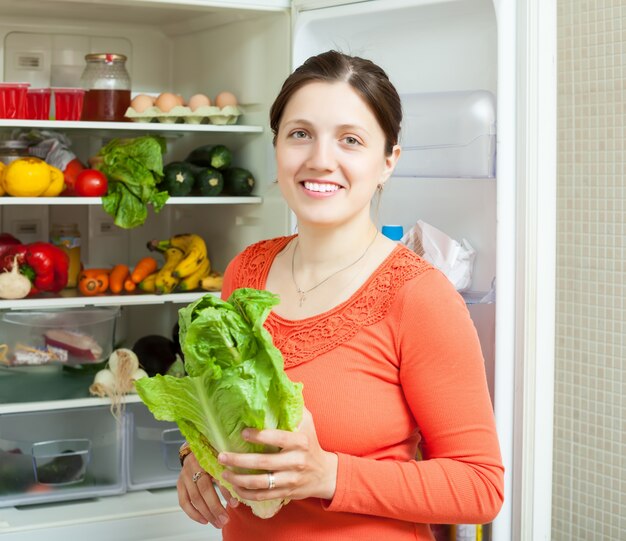 Szczęśliwa kobieta wprowadzenie warzyw do lodówki