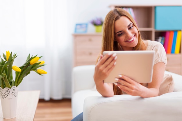 Szczęśliwa kobieta z cyfrowym tabletem w domu