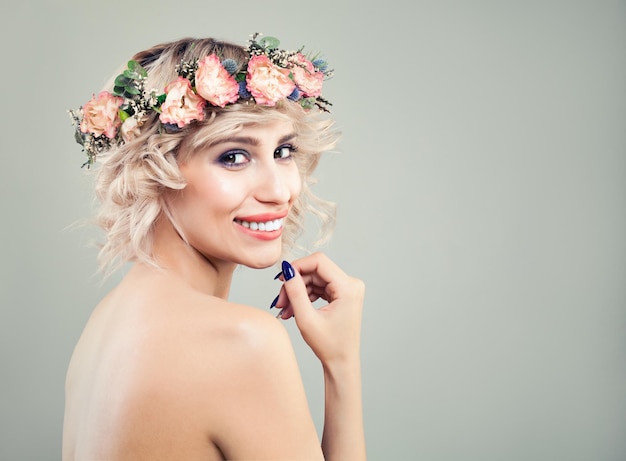 Szczęśliwa kobieta z kwiatami róży. uśmiechnięta modelka z blond włosami boba