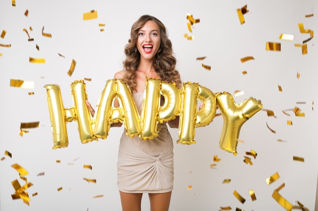 Bezpłatne zdjęcie szczęśliwa ładna kobieta obchodzi nowy rok w złotym konfetti