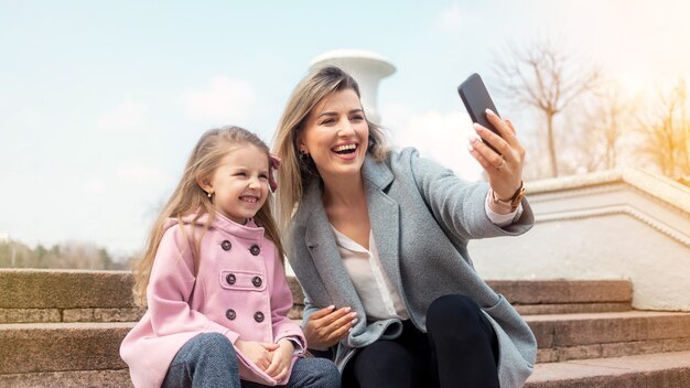 Szczęśliwa Mama I Córka, Biorąc Selfie Na Zewnątrz