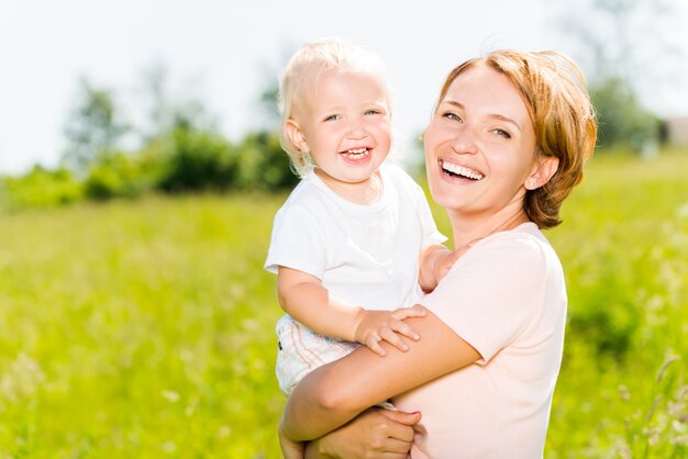 Szczęśliwa matka i syn malucha w portret odkryty łąka wiosna