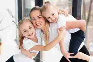 Bezpłatne zdjęcie szczęśliwa matka pozuje z córkami w domu