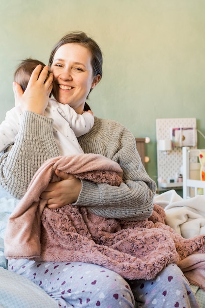 Bezpłatne zdjęcie szczęśliwa matka ściska ślicznego dziecka