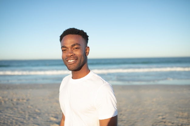 Szczęśliwa mężczyzna pozycja na plaży