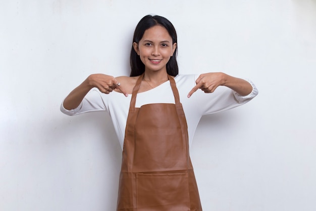 Szczęśliwa młoda azjatycka kelnerka barista wskazująca palcami w różnych kierunkach