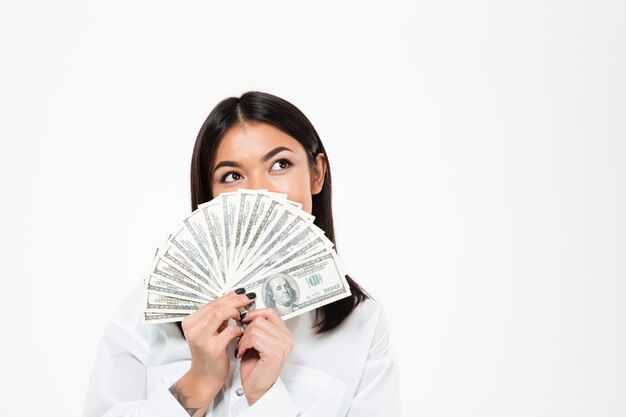 Szczęśliwa młoda azjatykcia kobiety nakrycia twarz z pieniądze.