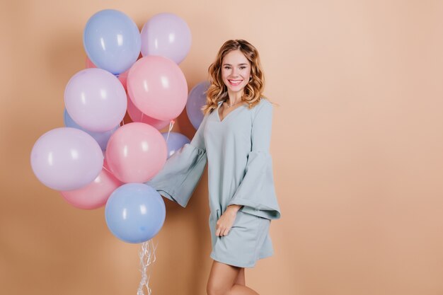 Szczęśliwa młoda dama w modnej niebieskiej sukience z balonów