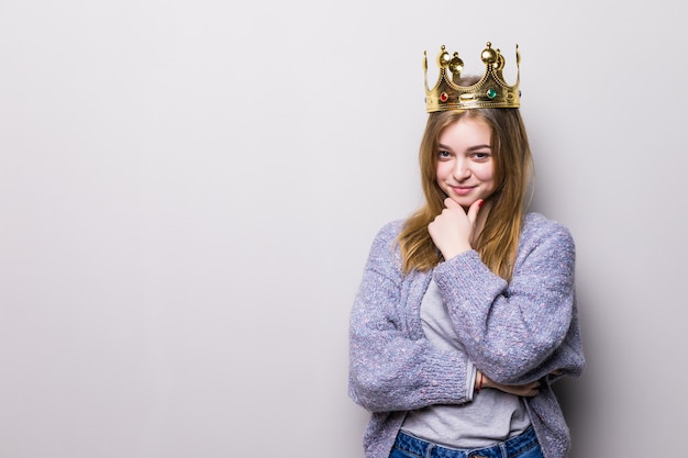 Bezpłatne zdjęcie szczęśliwa młoda kobieta lub dziewczyna nastolatka w koronie księżniczki na szarym tle