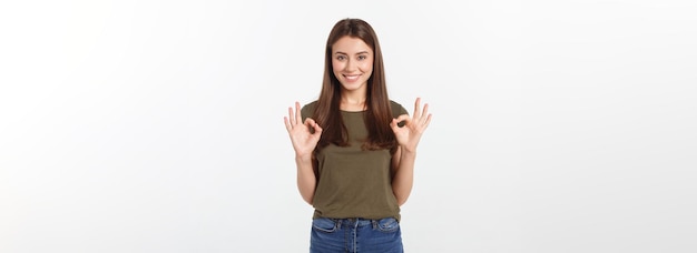 Szczęśliwa młoda kobieta pokazuje ok znak palcami mrugając na białym tle na szarym tle