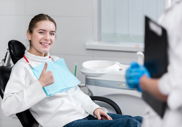 Szczęśliwa młoda kobieta przy dentystą