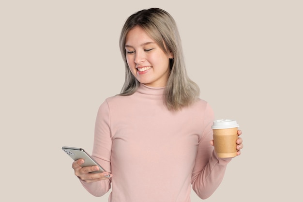 Szczęśliwa młoda kobieta używająca smartfona